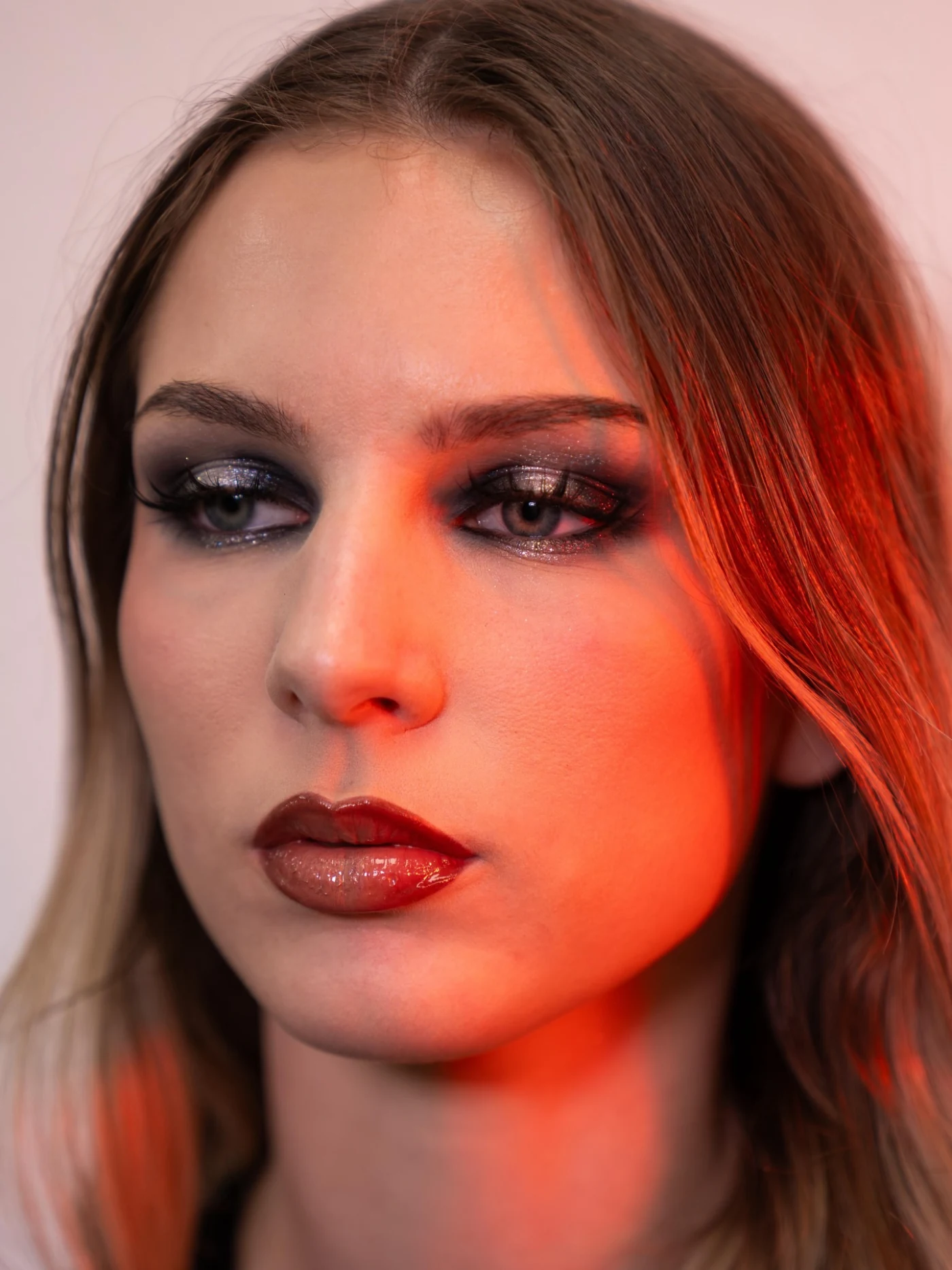 Portrait mode aux reflets rouges, maquillage professionnel.